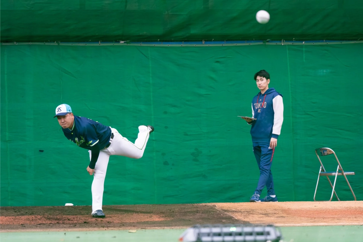 室内練習場で投球練習、タブレット確認
