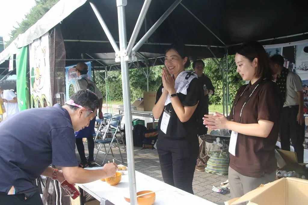 屋外イベントで試食を楽しむ人々