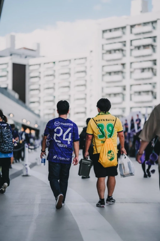 ユニフォーム姿の男性たちがスタジアムへ向かう