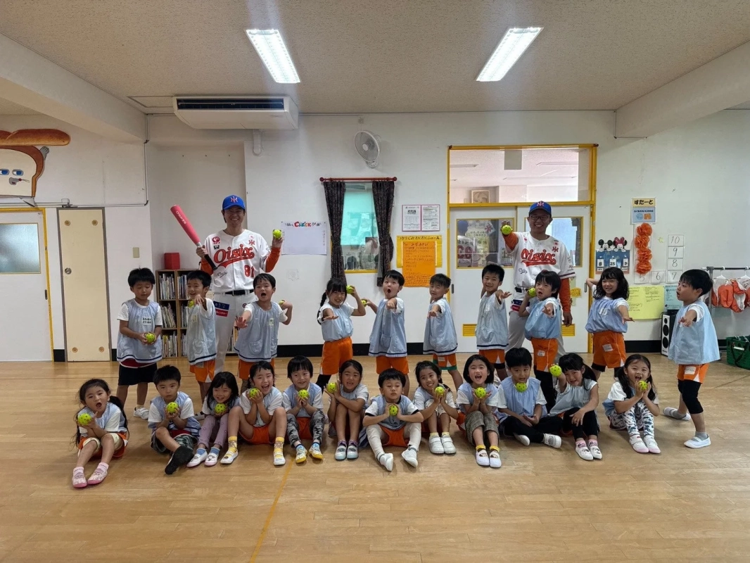 笑顔で集合写真に収まる子どもたちと野球関係者