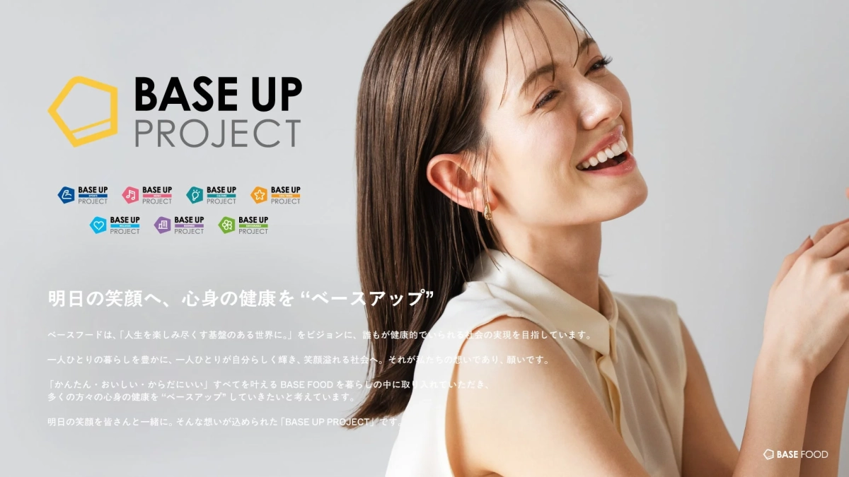 笑顔の女性が写る広告で、BASE FOODが提唱する「BASE UP PROJECT」を紹介