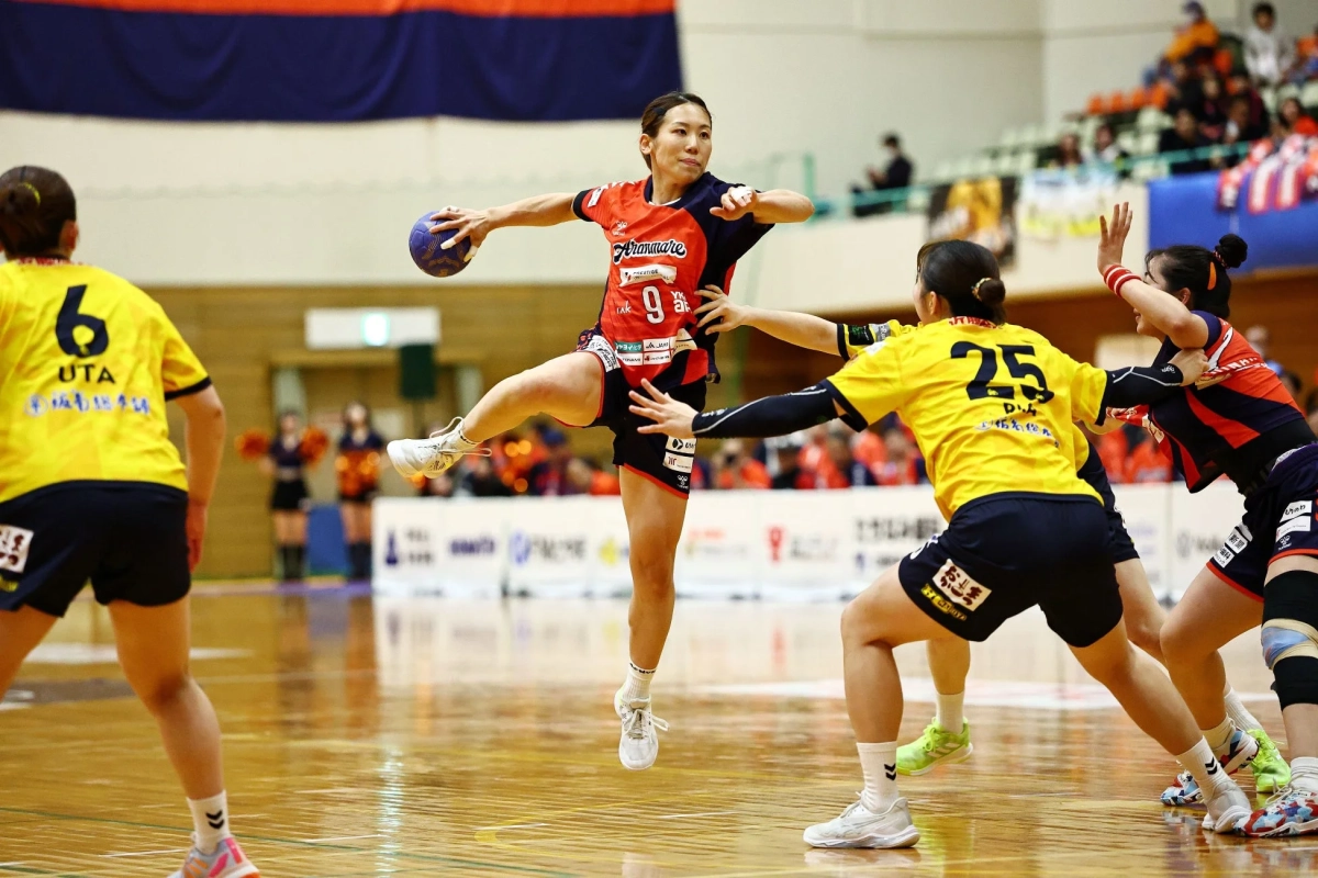 屋内コートで行われている女子ハンドボールの試合の一場面