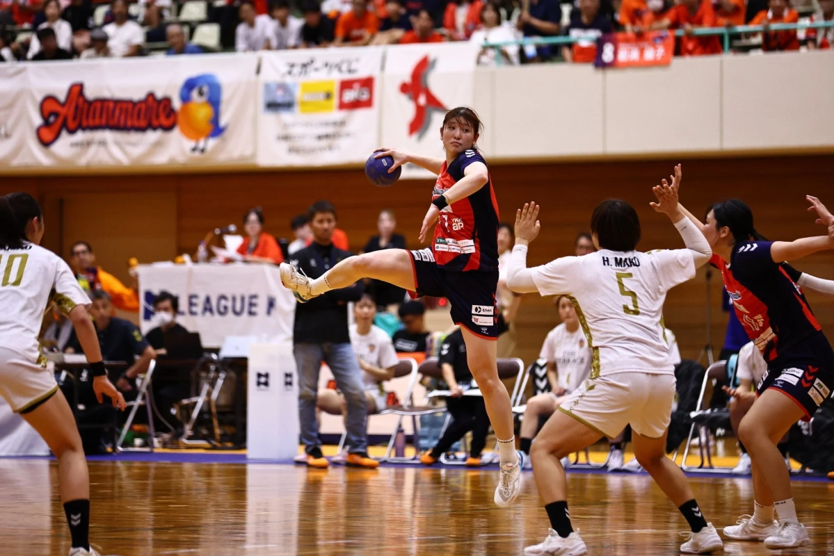 体育館で行われている女子ハンドボールの試合の一場面