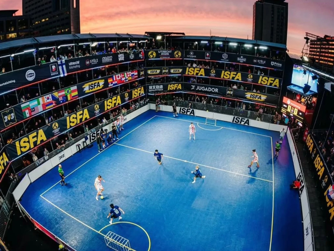 夕暮れの都市を背景に特設会場で行われている3v3フットサルの試合風景
