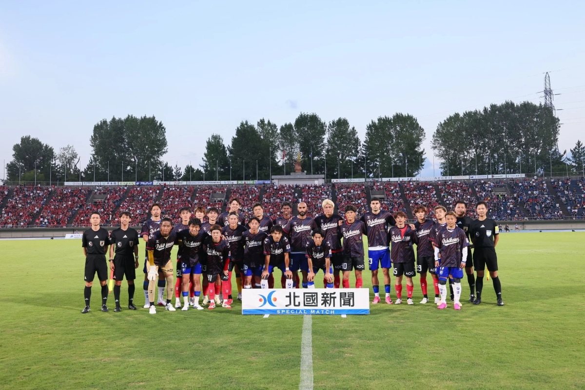サッカーチームと審判がスタジアムのピッチで撮影された集合写真